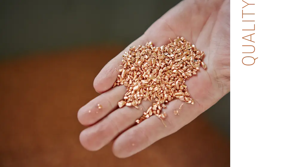 hand holds coppergranulate, lettering: quality