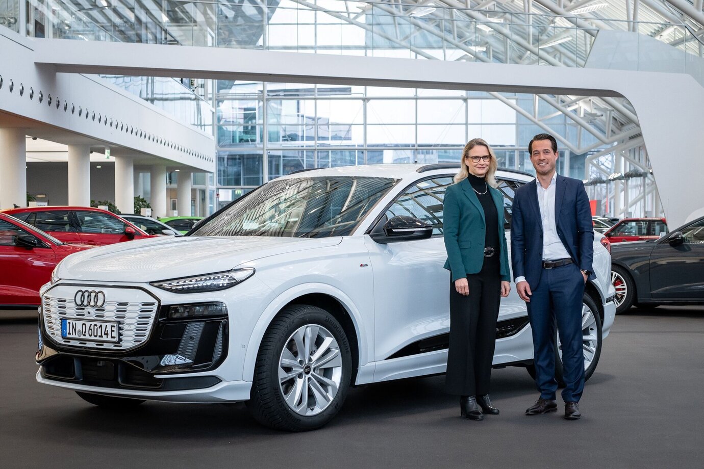Audi Beschaffungsvorständin Dr.-Ing. Renate Vachenauer (links) und TSR Resource Geschäftsführer Christian Blackert (rechts) stehen vor einem Auto von Audi