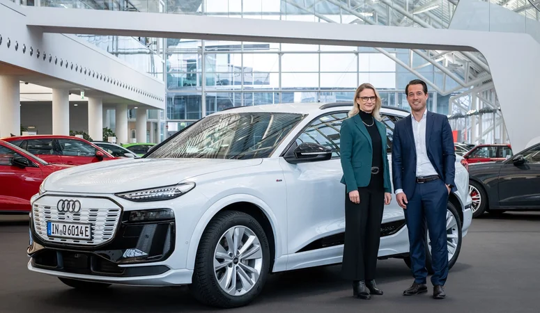 Audi Beschaffungsvorständin Dr.-Ing. Renate Vachenauer (links) und TSR Resource Geschäftsführer Christian Blackert (rechts) stehen vor einem Auto von Audi