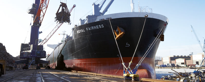 Beladung eines Containerschiffs mit Altmetall 