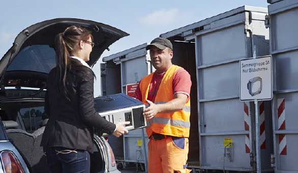 Schrottplatzmitarbeiter nimmt einen defekten Computer an, um diesen zu recyceln.