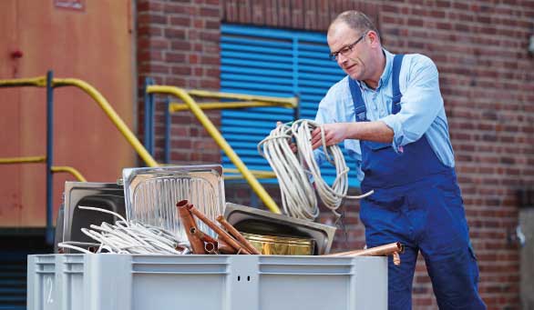 Handwerker legt Kabelreste und weiteres Altmetall in die Kleinbehälterlösung THE METAL BOX