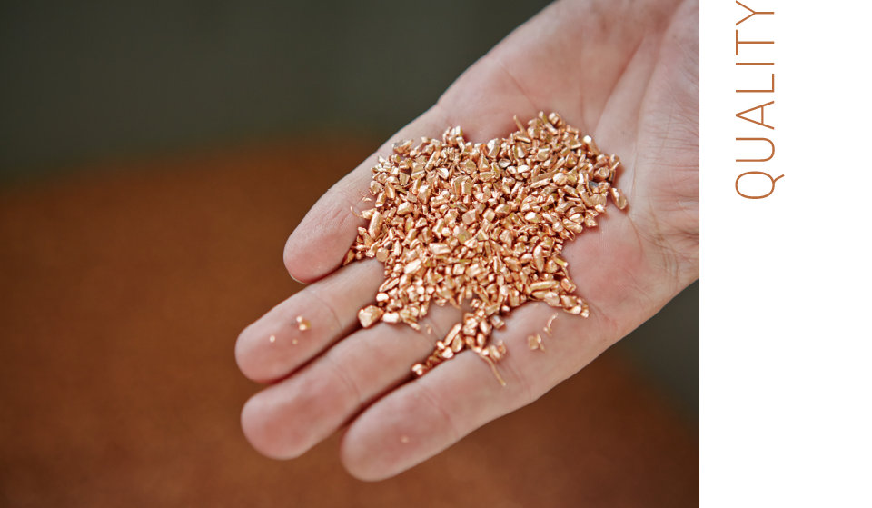 hand holds coppergranulate, lettering: quality